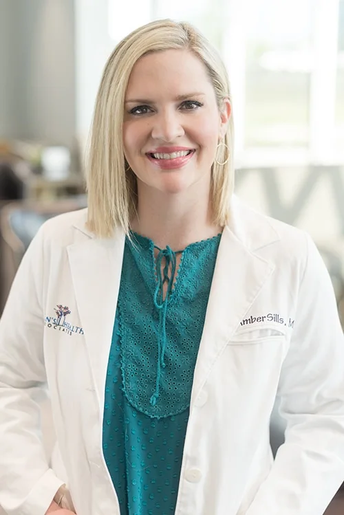 Dr. Amber Sills in a white coat over a teal blouse